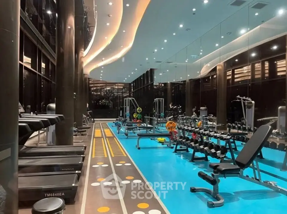 Luxurious gym with modern equipment and ambient lighting in a high-end residential building.