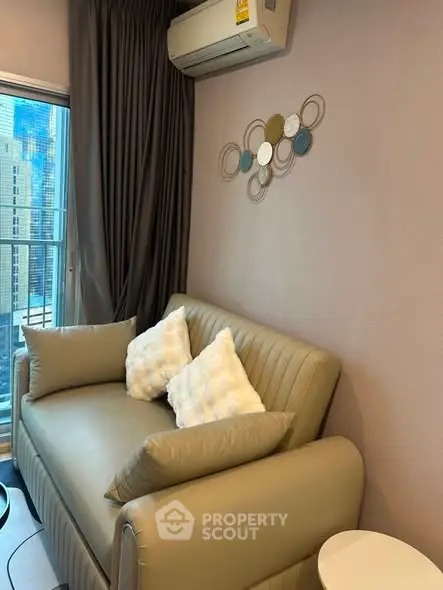 Cozy living room with modern decor and city view, featuring a stylish sofa and air conditioning.