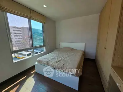 Cozy bedroom with large window and built-in wardrobe, perfect for natural light lovers.