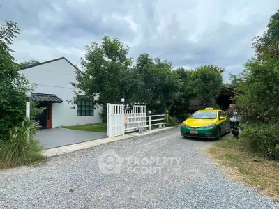 Charming suburban home with lush greenery and spacious driveway, perfect for serene living.