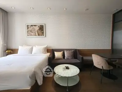 Modern studio apartment with cozy bed and stylish seating area