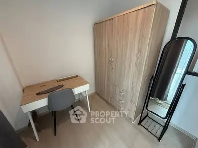 Modern study room with sleek desk, chair, and wooden wardrobe in cozy apartment.