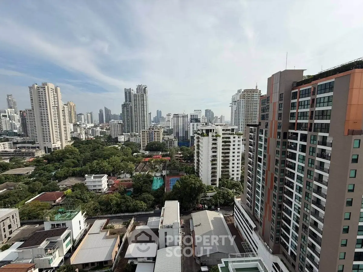 Stunning cityscape view from high-rise building showcasing urban skyline and lush greenery.