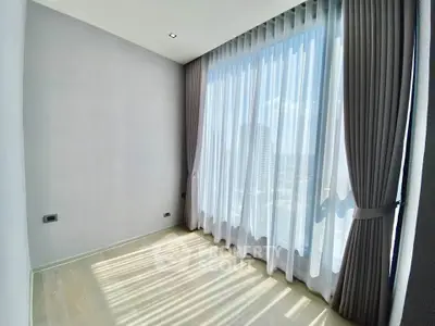 Bright empty room with large window and elegant curtains, perfect for customization.