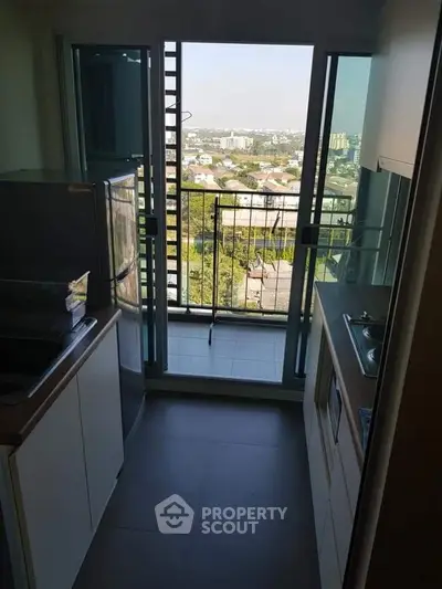 Compact kitchen with balcony view in modern apartment