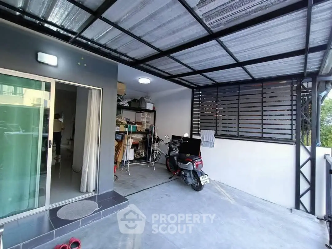 Covered parking area with sliding glass door and storage shelves