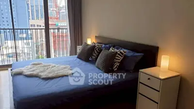 Modern bedroom with city view, featuring cozy bed and stylish decor.