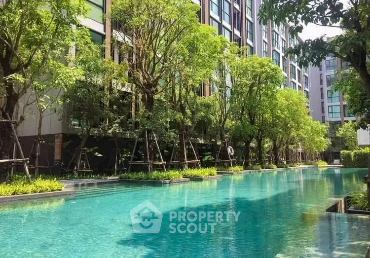 Luxurious residential pool surrounded by lush greenery and modern architecture.