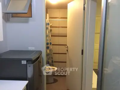 Compact bathroom with modern fixtures and washing machine, ideal for small apartments.