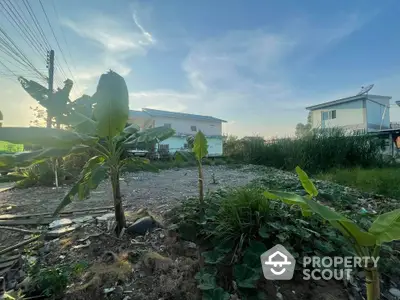 Spacious garden area with lush greenery and residential buildings in the background.