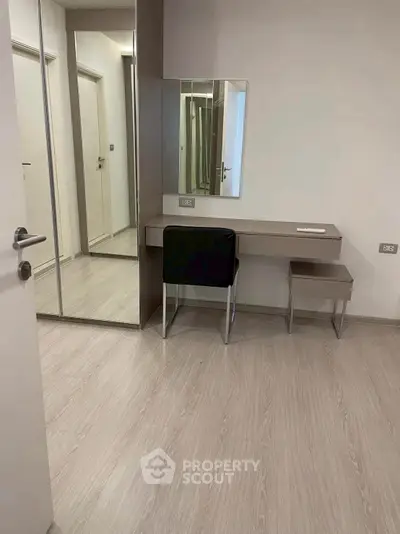 Modern bedroom with sleek vanity and mirrored wardrobe
