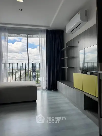 Modern living room with large window and sleek furniture, offering a bright and airy atmosphere.