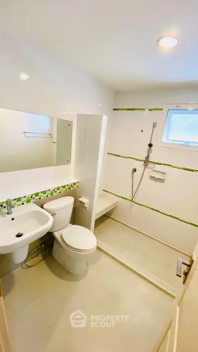 Modern bathroom with sleek fixtures and walk-in shower, featuring a minimalist design and bright lighting.