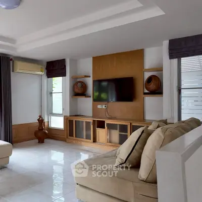 Spacious living room with modern decor and wall-mounted TV, perfect for relaxation.