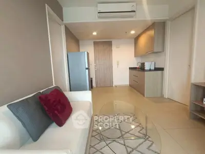 Modern living room with sleek kitchen and cozy decor in a stylish apartment.