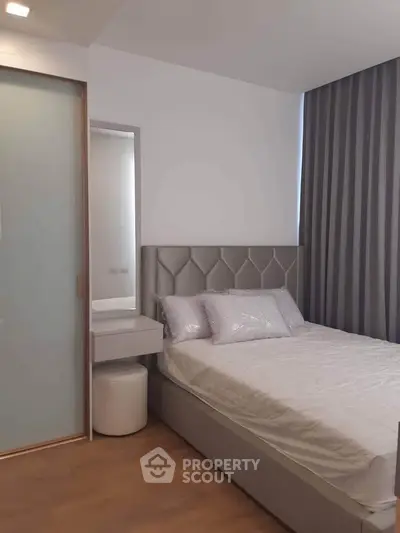 Modern bedroom with stylish headboard and floor-to-ceiling curtains, perfect for a cozy retreat.