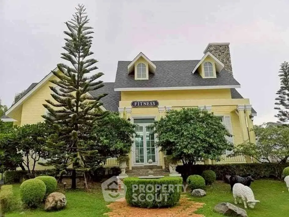 Charming yellow house with lush garden and unique architectural design