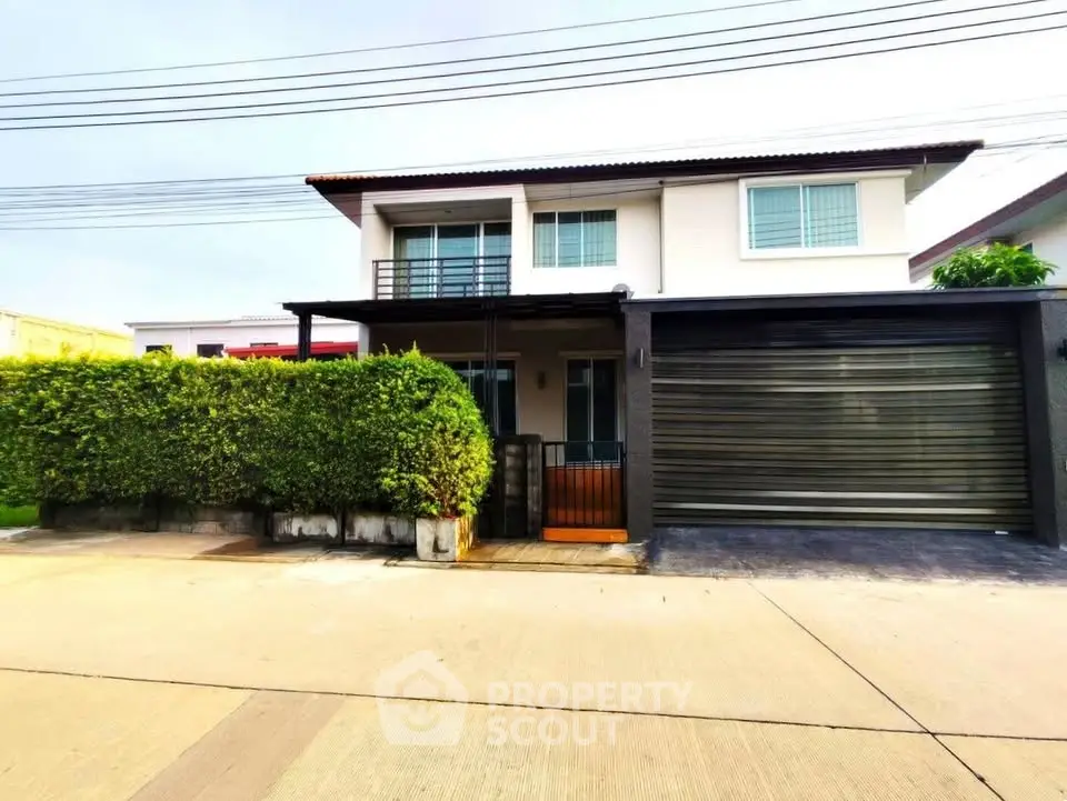 Modern two-story house with garage and lush greenery in a suburban setting.