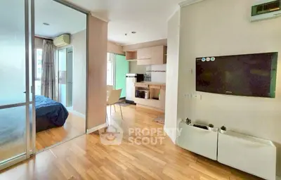 Modern open-plan living area with wooden flooring and wall-mounted TV