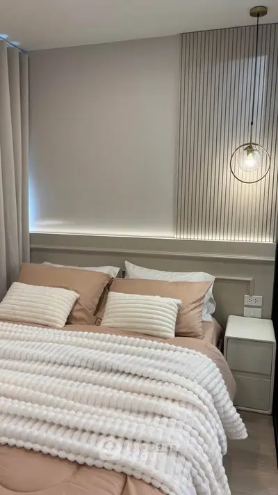 Modern bedroom with stylish decor and cozy bedding in a contemporary apartment.