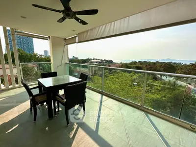 Spacious balcony with stunning view and outdoor dining area in modern apartment.