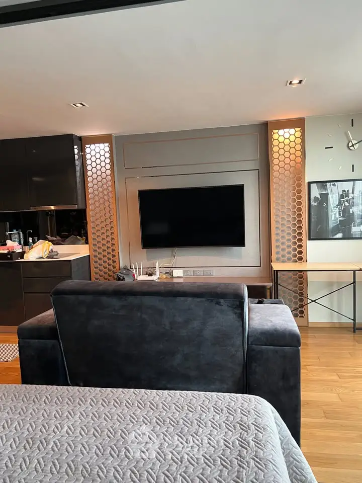 Modern living room with sleek design, featuring a wall-mounted TV and stylish decor, perfect for urban living.