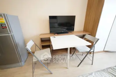 Modern apartment interior with sleek dining area and flat-screen TV