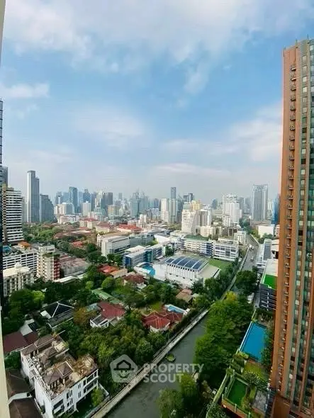 Stunning cityscape view from high-rise apartment overlooking urban skyline and lush greenery.