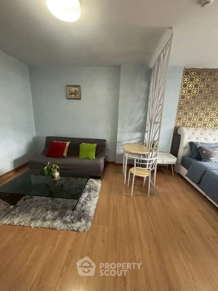 Chic studio apartment with modern decor, cozy seating area, and stylish partition for privacy.