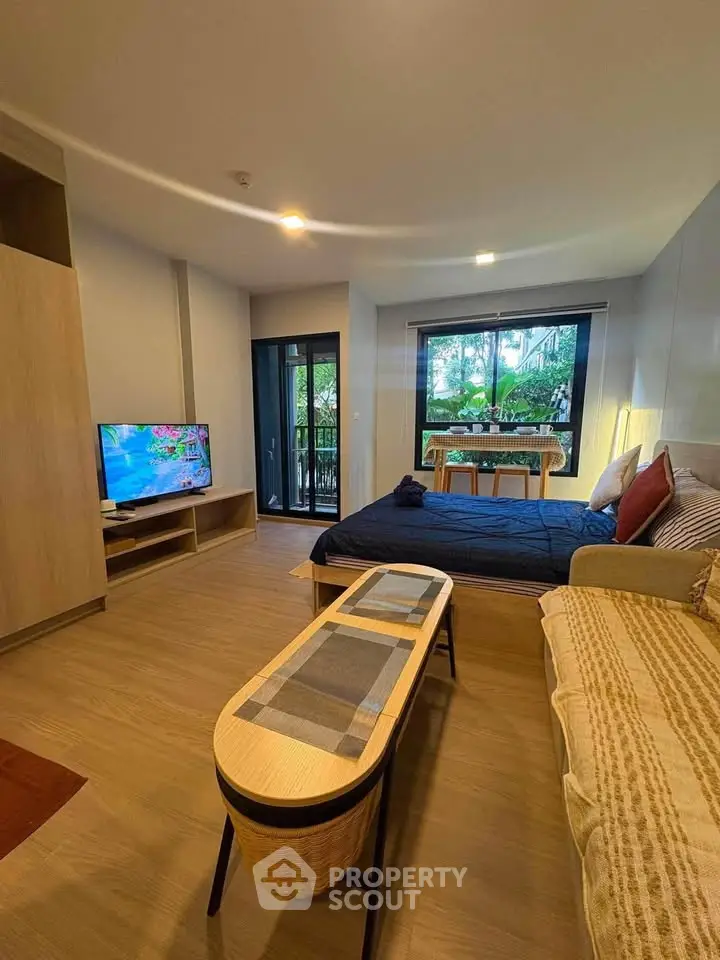 Modern studio apartment with cozy living area and balcony view