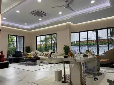 Luxurious modern living room with elegant decor and large windows offering natural light.