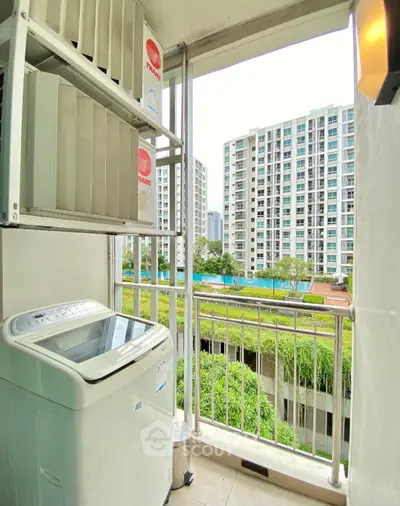 Charming balcony with washing machine and scenic view of modern apartment complex.