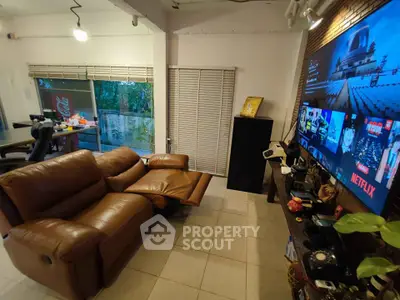Cozy living room with leather recliner and large TV screen, perfect for entertainment.
