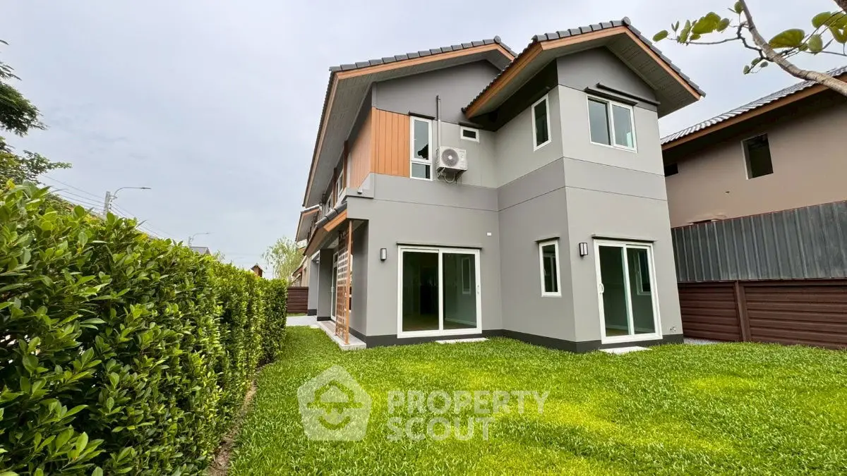 Modern two-story house with lush green lawn and contemporary design