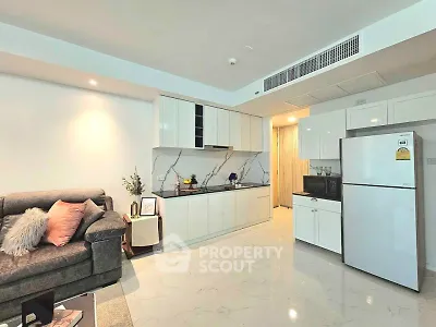 Modern open-layout living room with sleek kitchen and cozy sofa, perfect for urban living.