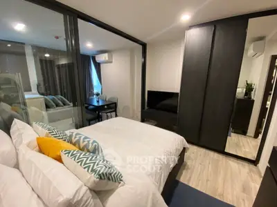 Modern bedroom with glass partition and stylish decor in a contemporary apartment.