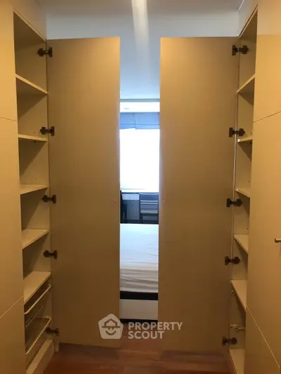 Spacious walk-in closet leading to a bright bedroom with ample storage and natural light.