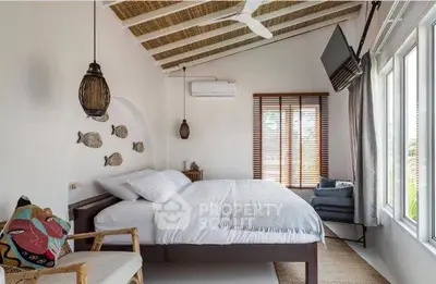 Charming bedroom with rustic decor and large windows offering natural light.
