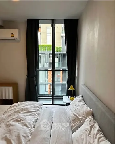 Cozy bedroom with large window and modern decor in urban apartment