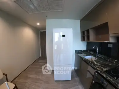 Modern kitchen with sleek appliances and marble countertops in a stylish apartment.
