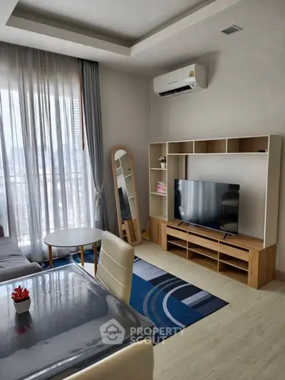 Modern living room with stylish furniture and large window view.