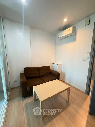Cozy living room with brown sofa and modern air conditioning unit