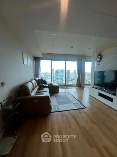 Spacious living room with large windows offering stunning city views, modern furnishings, and elegant decor.