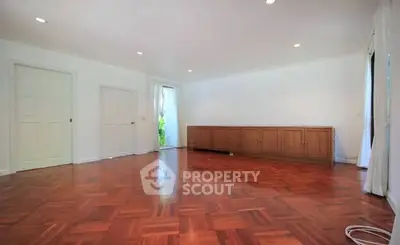 Spacious empty living room with wooden flooring and natural light