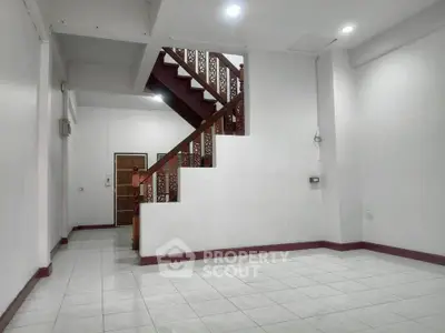 Spacious interior with elegant staircase and tiled flooring, perfect for modern living.
