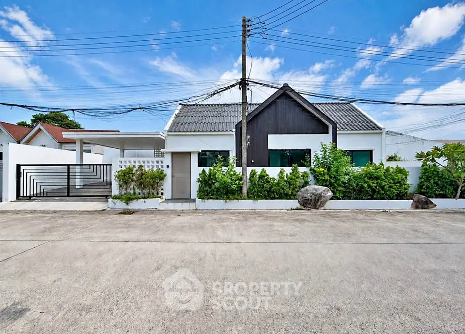 Charming modern house with lush greenery and spacious driveway under a clear blue sky.