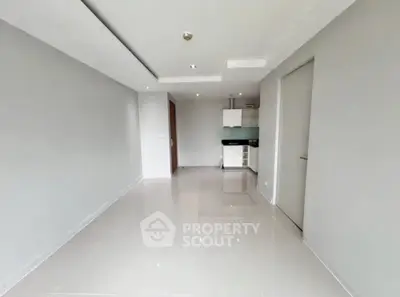 Spacious modern apartment interior with sleek kitchen and glossy tiled floors.