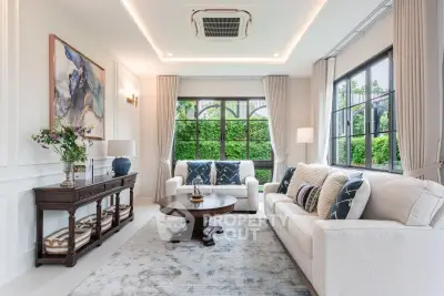 Elegant living room with large windows, stylish decor, and lush garden view, perfect for relaxation.