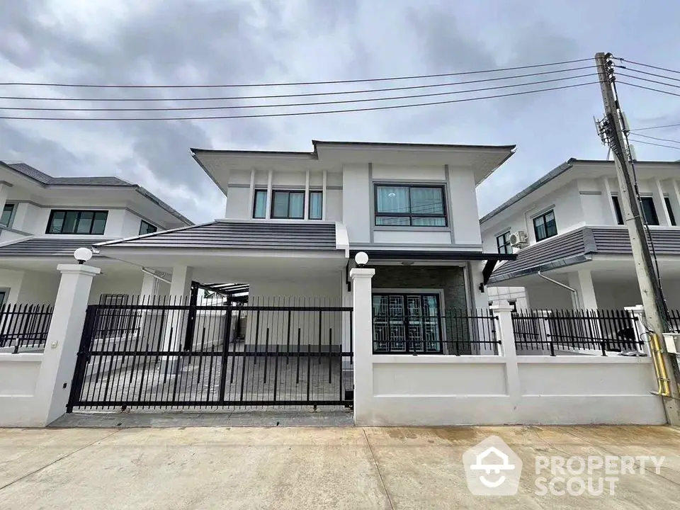 Modern two-story house with gated entrance and spacious driveway