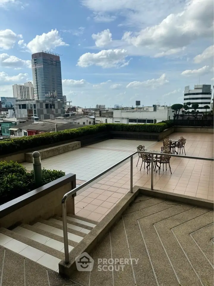 Spacious rooftop terrace with city views and outdoor seating, perfect for relaxation.